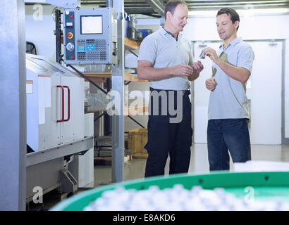 Engineers in discussion in CNC precision engineering centre Stock Photo