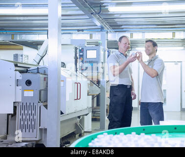 Engineers in discussion in CNC precision engineering centre Stock Photo
