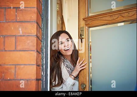 Woman opening front door Stock Photo