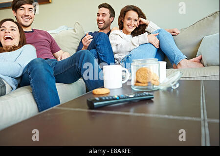 Group of friends watching sport in living room Stock Photo
