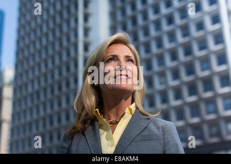 Mature businesswoman in front of building, looking away Stock Photo