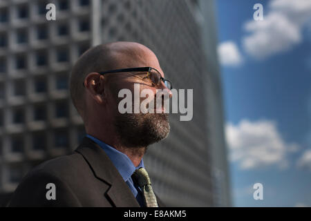Mature businessman in front of building, looking away Stock Photo