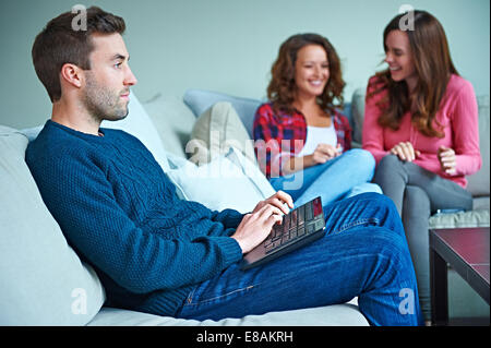 Friends sitting in living room together Stock Photo