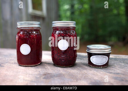 Three jars of jam on garden table Stock Photo