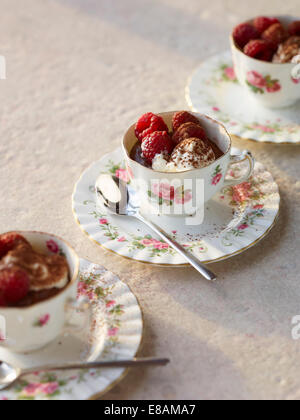 Chocolate mousse with raspberries and cream in vintage tea cups Stock Photo