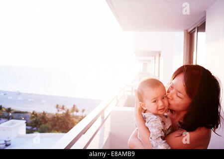 Portrait of mid adult mother and baby son on apartment balcony