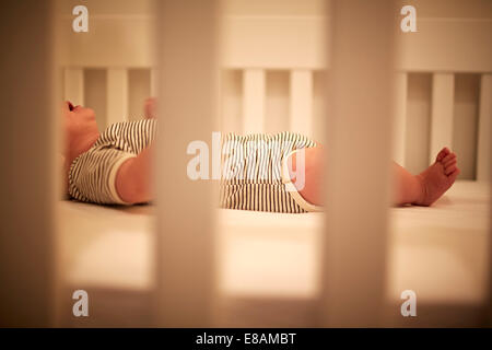 Baby boy asleep in crib with mouth open Stock Photo