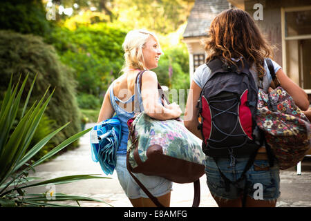 Rear view of two female friends out walking with backpack and bags Stock Photo