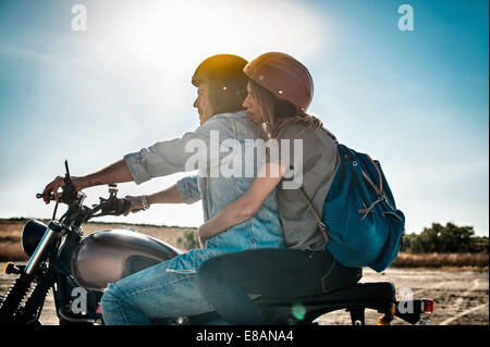 Mid adult couple motorcycling on arid plain, Cagliari, Sardinia, Italy Stock Photo