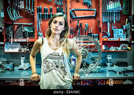 Portrait of young female mechanic in motorcycle workshop Stock Photo