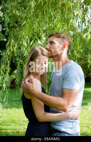 Mid adult couple embracing in garden Stock Photo