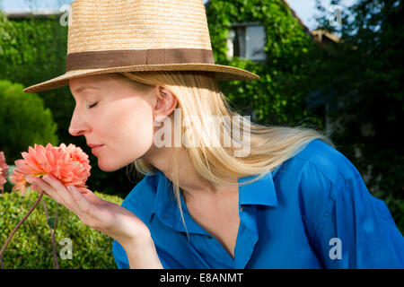 Close up of mid adult woman smelling garden bloom Stock Photo