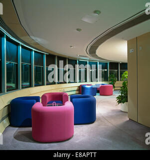 Bright pink and cobalt blue tub chairs in meeting area in city office Stock Photo
