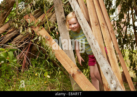 Portrait of girl hiding in garden den Stock Photo