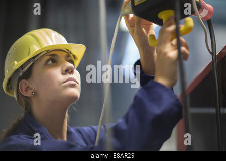 Female engineer checking valves and cables in factory Stock Photo