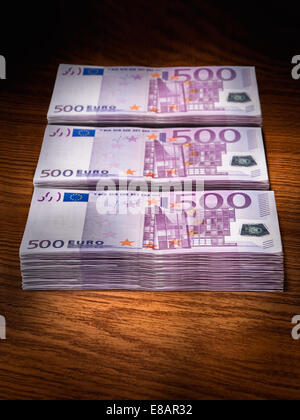 Three stacks of 500 euro bills on office desk Stock Photo