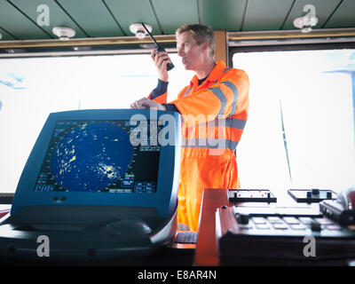 Ship's worker on bridge using walkie-talkie Ship's worker on bridge using walkie-talkie