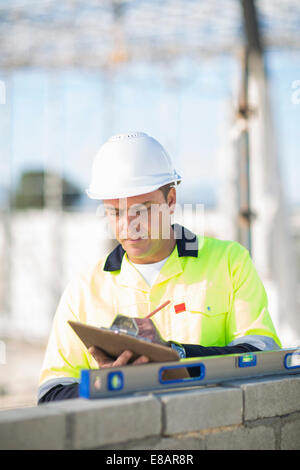 Site manager checking spirit level on construction site wall