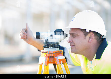Surveyor looking through level on construction site Stock Photo