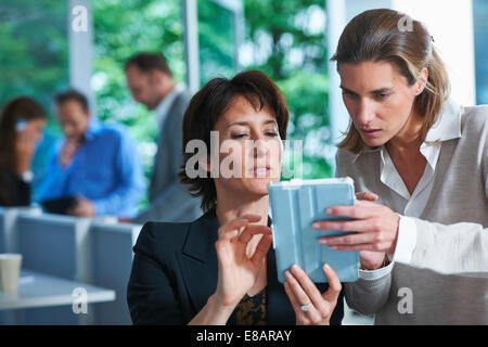Two business women looking at digital tablet in office