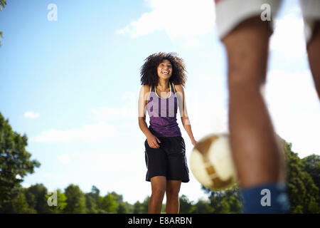 Young couple playing football in park Stock Photo