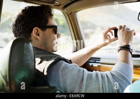 Young man photographing through windscreen, Cape Town, Western Cape, South Africa Stock Photo