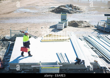 High angle view of surveyor carrying case and tripod on construction site Stock Photo