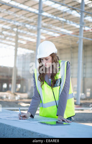 Architect adjusting blueprint on construction site Stock Photo