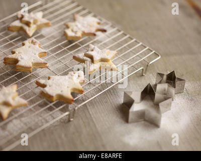 Close up of freshly baked christmas biscuits on cooling rack Stock Photo