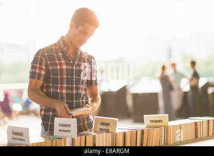 Young man at second hand book stall Stock Photo