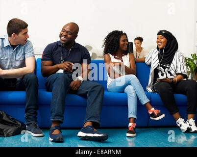 Male lecturer chatting to students in college Stock Photo