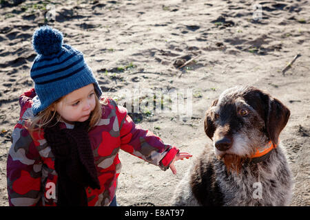 Young girl stroking dog Stock Photo