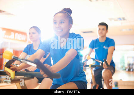 Young woman on exercise bike Stock Photo