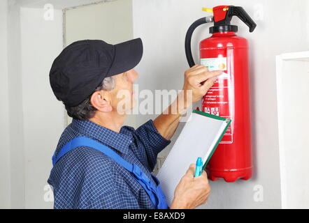 A Professional checking aFire extinguisher Stock Photo