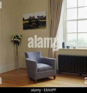 Pale mauve wool armchair beside window with gray silk curtain in traditional living room Stock Photo