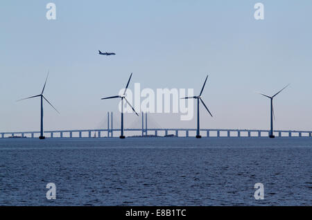 Wind turbines at Middelgrunden offshore wind farm in front of the Øresund Bridge and a Qatar Airways airplane approaching Copenhagen Airport on Amager Stock Photo