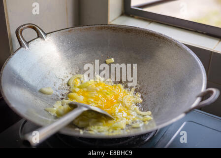 Asian style stir fry eggs and onions cooking in a wok Stock Photo