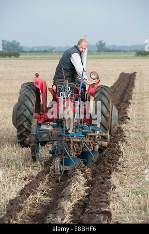 Cottenham, Cambridgeshire, UK. 4th October, 2014. Competitors take part in the Cottenham and District Ploughing Society match at Long Drove, Cottenham, Cambridgeshire, UK 4th October 2014.  Under big skies just north of Cambridge on the edge of the Fens, competitors aimed to keep straight lines and a precise finish in various categories including vintage and rotavators. Credit Julian Eales/Alamy Live News Stock Photo