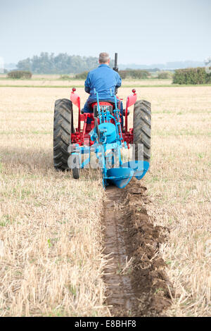 Cottenham, Cambridgeshire, UK. 4th October, 2014. Competitors take part in the Cottenham and District Ploughing Society match at Long Drove, Cottenham, Cambridgeshire, UK 4th October 2014.  Under big skies just north of Cambridge on the edge of the Fens, competitors aimed to keep straight lines and a precise finish in various categories including vintage and rotavators. Credit Julian Eales/Alamy Live News Stock Photo