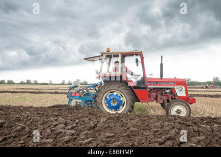 Cottenham, Cambridgeshire, UK. 4th October, 2014. Competitors take part in the Cottenham and District Ploughing Society match at Long Drove, Cottenham, Cambridgeshire, UK 4th October 2014.  Under big skies just north of Cambridge on the edge of the Fens, competitors aimed to keep straight lines and a precise finish in various categories including vintage and rotavators. Credit Julian Eales/Alamy Live News Stock Photo