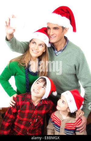 Family of four making a selfie for Christmas. Isolated on white. Stock Photo