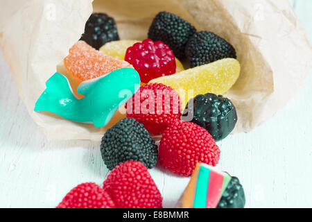 Bag of delicious candy, jelly beans scattered on white table Stock Photo