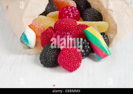 Bag of delicious candy, jelly beans scattered on white table Stock Photo