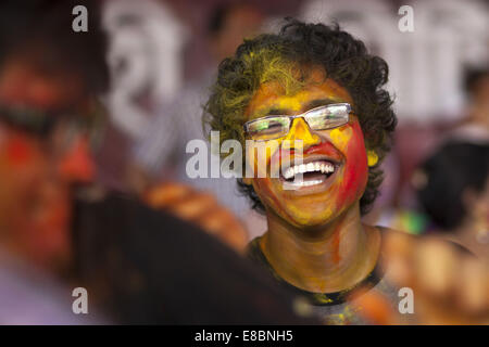 Dhaka, Bangladesh. 4th Oct, 2014. Bangladeshi Hindu devotees put vermillion and color on each other's faces as they dance on the final day of the Durga Puja Festival in Dhaka on October 4 2014. The five-day Durga Puja festival commemorates the slaying of a demon king Mahishasur by goddess Durga, marking the triumph of good over evil. Credit:  Zakir Hossain Chowdhury/ZUMA Wire/Alamy Live News Stock Photo