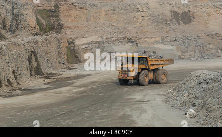 A large caterpillar mining truck hauls ore in a large open cast copper mine in Africa. Stock Photo