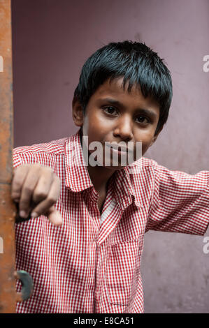 Young Indian boy who looks outside on the doorstep Stock Photo