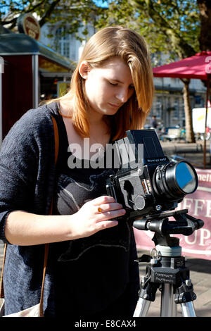 young female photography student learning to use a medium format roll film camera Stock Photo