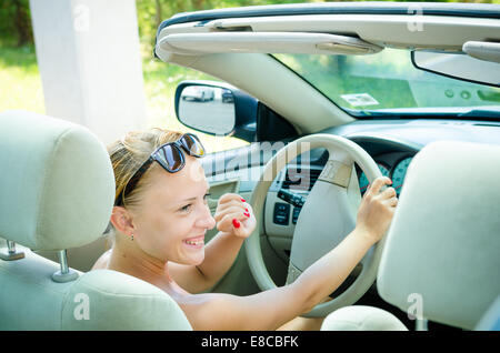 Beautiful blond woman driving her convertible car Stock Photo