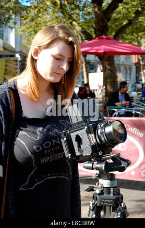 young female photography student learning to use a medium format roll film camera Stock Photo