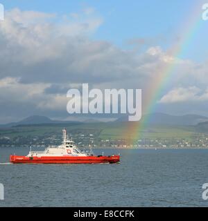 A break in the heavy rain and the appearance of sunshine results in this rainbow over the car ferry at Gourock, Scotland Stock Photo